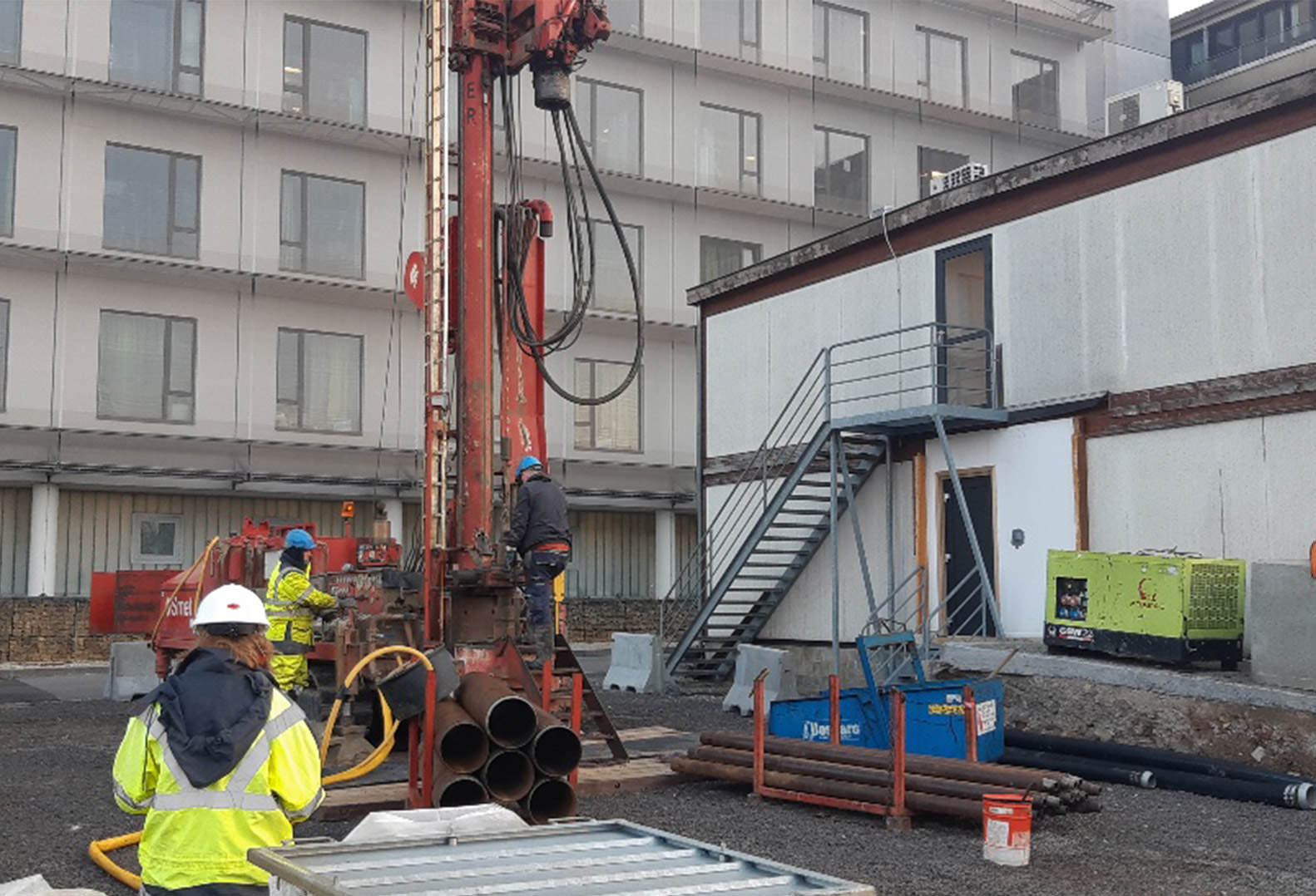 Three people work on the drilling phase of a geothermal well