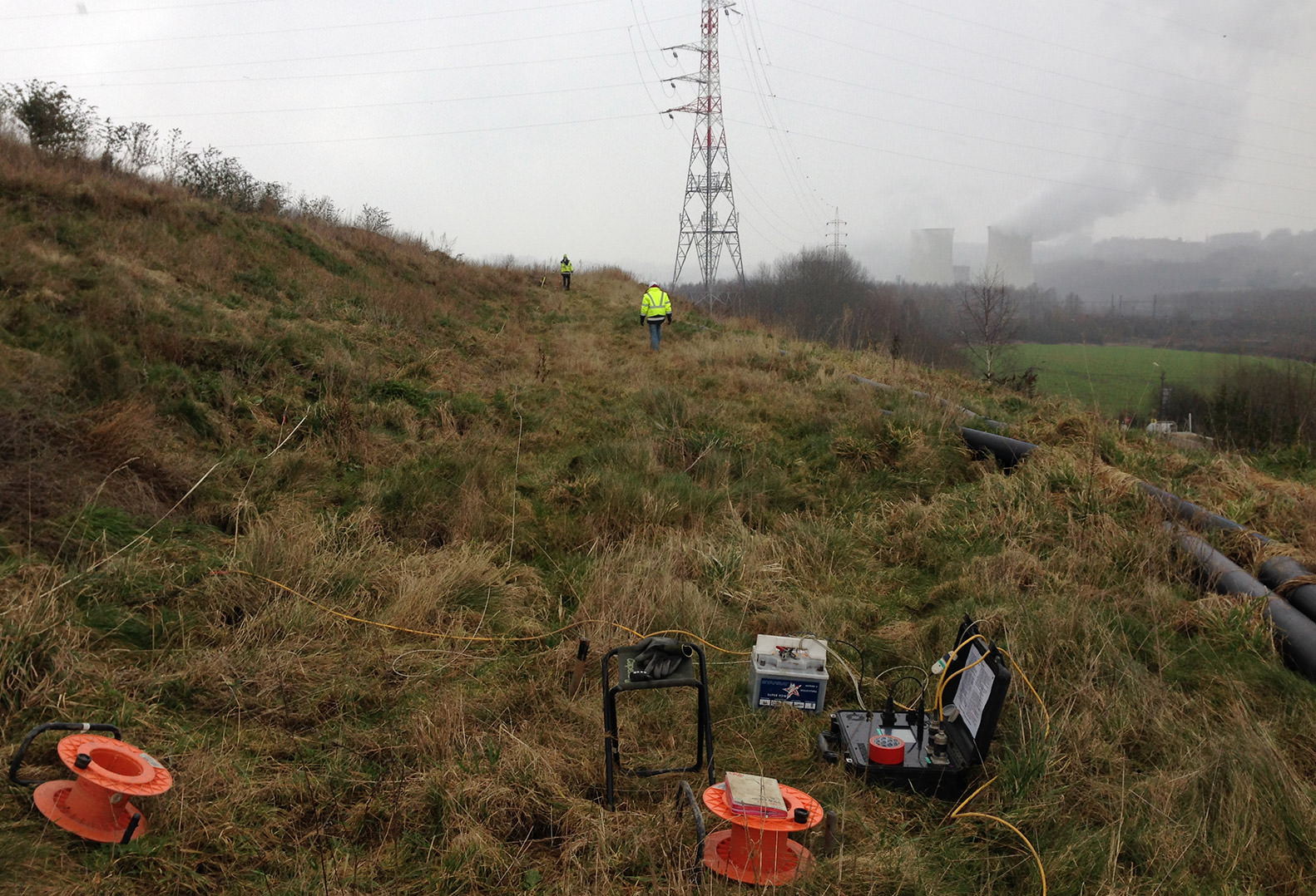 Two men in Hi-Vis perform Geophysical Data Acquisition on Belgium property