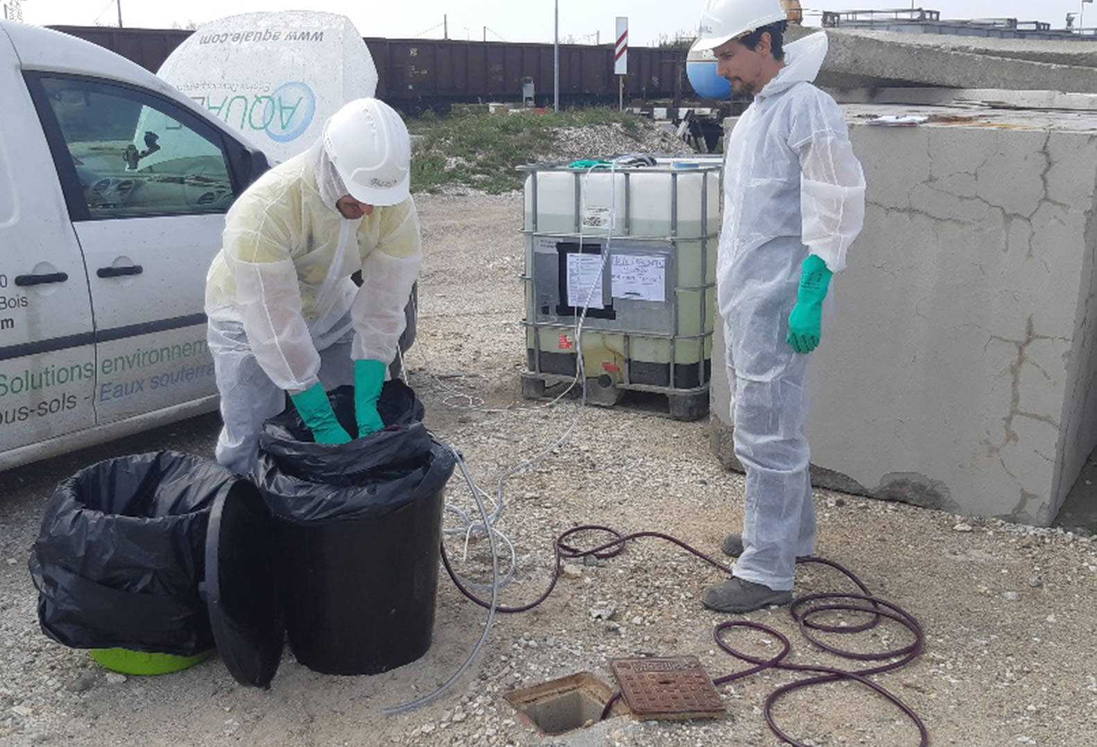 Two men wearing personal protective equipment start tracer test injection